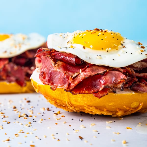 Close-up of a Beverly Hills Bagel breakfast sandwich with pastrami and a fried egg.